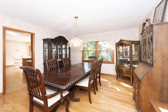 dining room with light hardwood / wood-style flooring and a notable chandelier