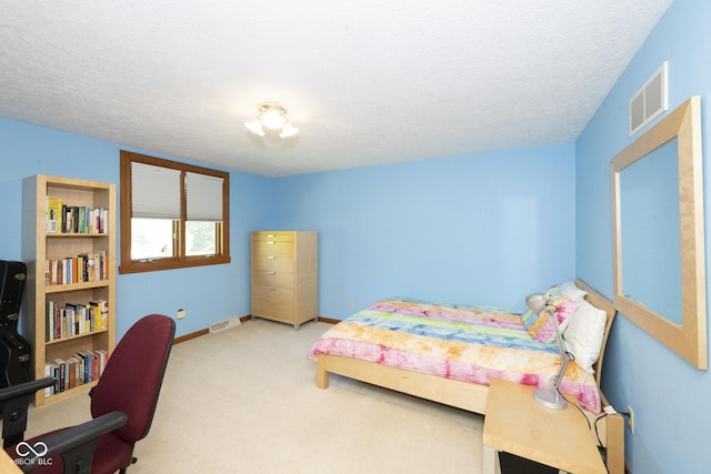 bedroom with a textured ceiling and light colored carpet