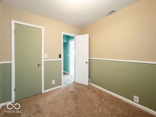 spare room with carpet flooring and a textured ceiling