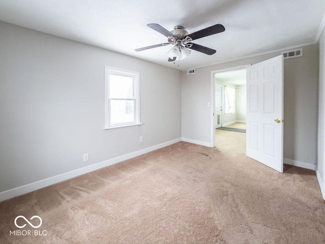 unfurnished room with light carpet, crown molding, and ceiling fan