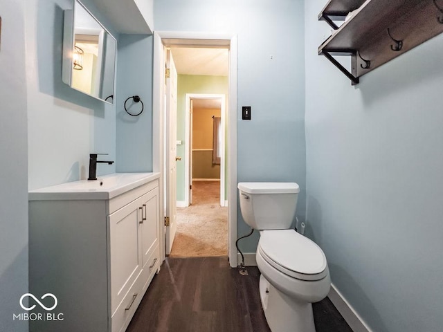 bathroom featuring vanity, wood-type flooring, and toilet