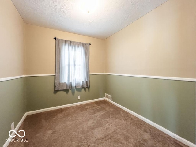 carpeted empty room with a textured ceiling