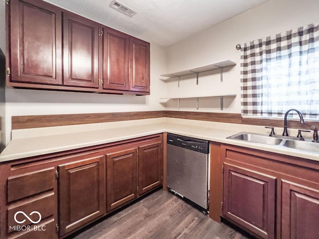 kitchen featuring dishwasher, sink, dark wood-type flooring, and a textured ceiling