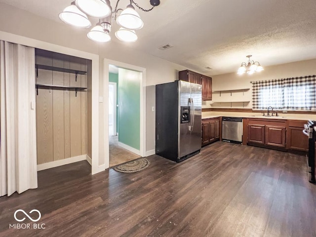 kitchen with appliances with stainless steel finishes, dark hardwood / wood-style floors, sink, and a notable chandelier