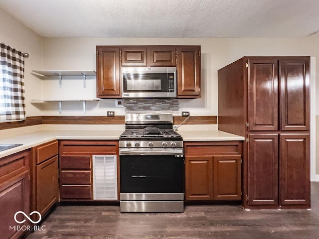 kitchen featuring dark wood-type flooring, appliances with stainless steel finishes, and a textured ceiling