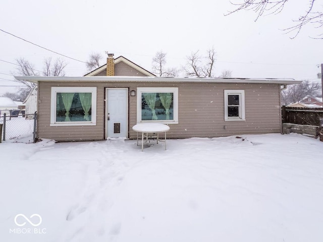 view of snow covered back of property