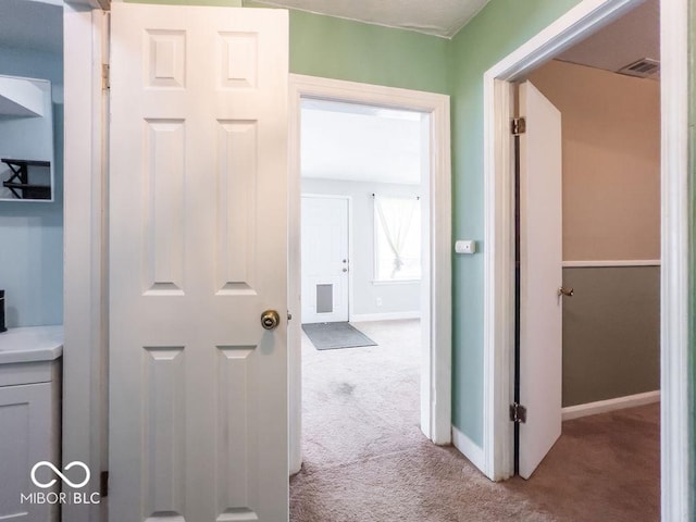 hallway featuring light colored carpet