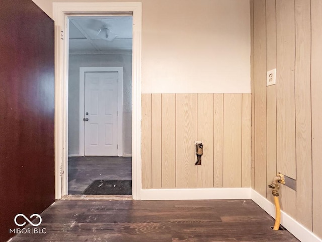 interior space with dark wood-type flooring and wood walls