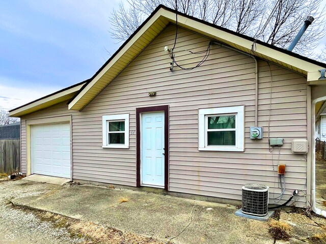 back of house featuring cooling unit and a garage