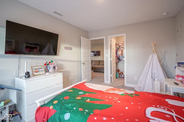 carpeted bedroom featuring a spacious closet and a closet