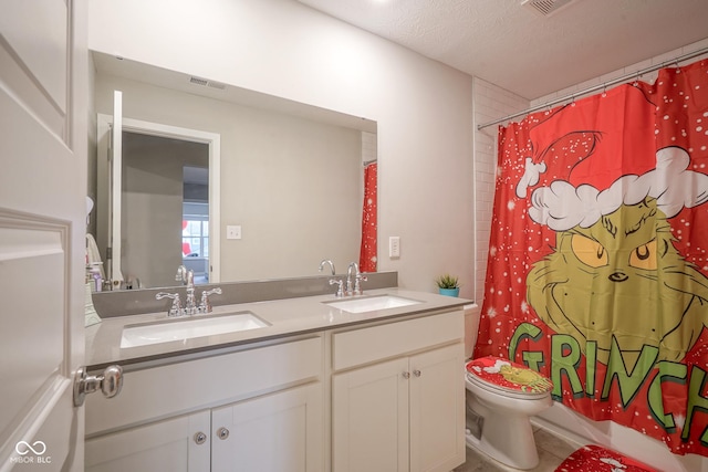 bathroom featuring vanity, a textured ceiling, and toilet