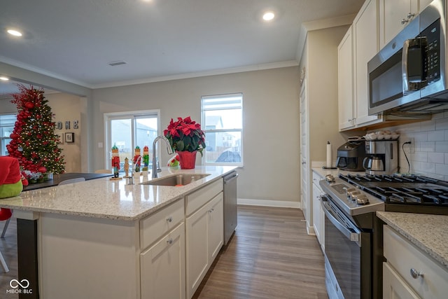 kitchen featuring white cabinets, a kitchen island with sink, sink, and appliances with stainless steel finishes