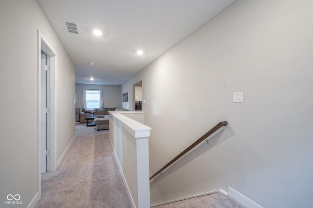 hall with light colored carpet