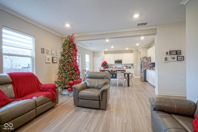 living room with light hardwood / wood-style floors and crown molding