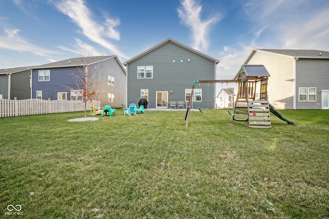 back of property with a lawn and a playground