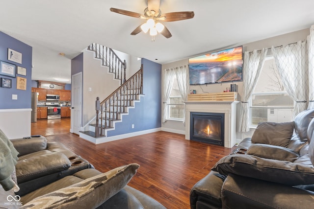 living room featuring ceiling fan and dark wood-type flooring