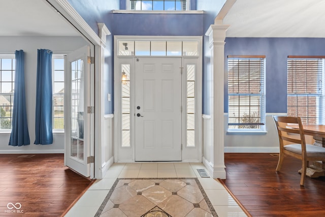 tiled foyer featuring decorative columns and plenty of natural light