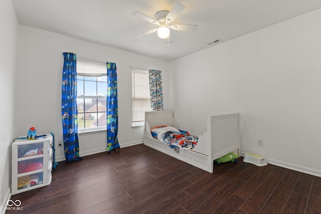 unfurnished bedroom with ceiling fan and dark wood-type flooring