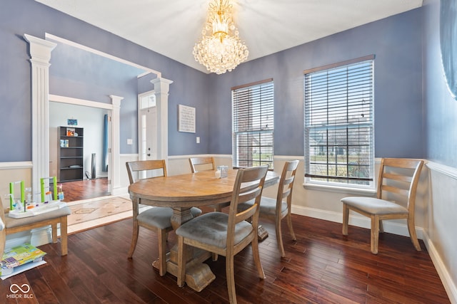 dining area featuring a healthy amount of sunlight, dark hardwood / wood-style flooring, decorative columns, and a notable chandelier