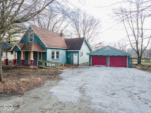 view of front of property with a porch, a garage, and an outdoor structure