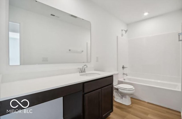 full bathroom featuring vanity, toilet, washtub / shower combination, and hardwood / wood-style flooring