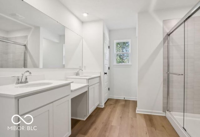 bathroom with a shower with door, vanity, and hardwood / wood-style flooring