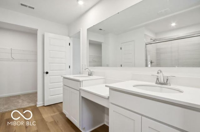 bathroom featuring hardwood / wood-style flooring, vanity, and an enclosed shower