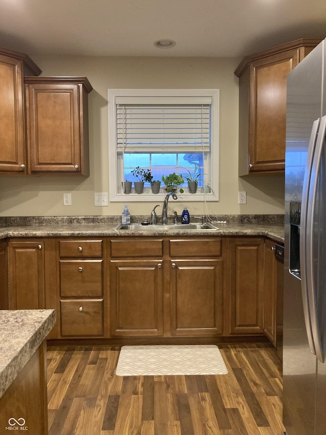 kitchen featuring stainless steel fridge with ice dispenser, sink, and dark wood-type flooring