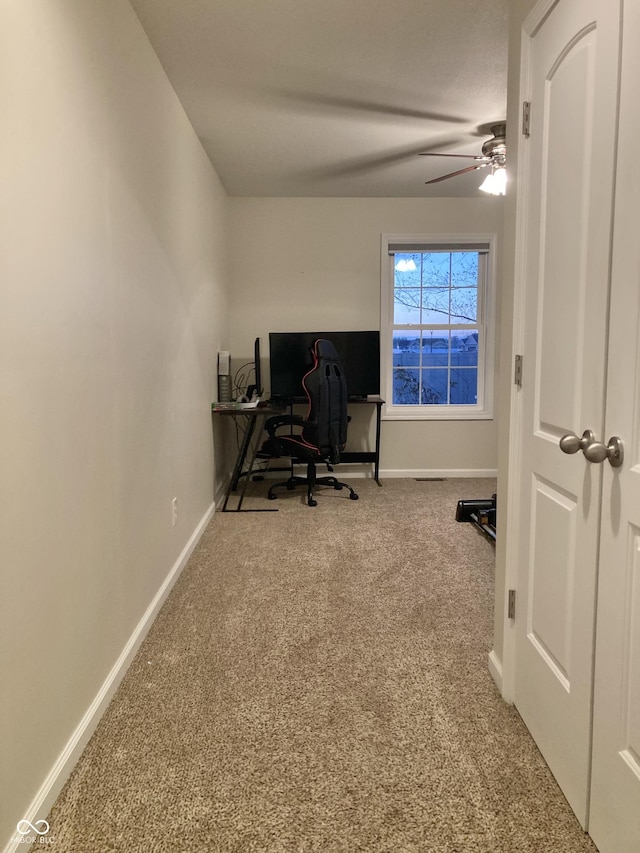 carpeted office featuring ceiling fan