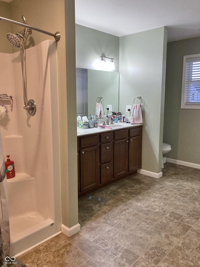 bathroom featuring a shower, vanity, and toilet