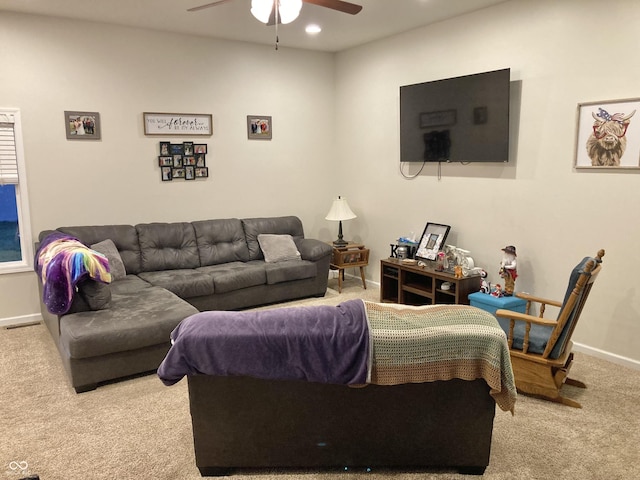 carpeted living room with ceiling fan