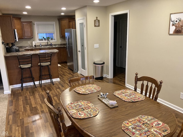 dining space with dark hardwood / wood-style floors and sink