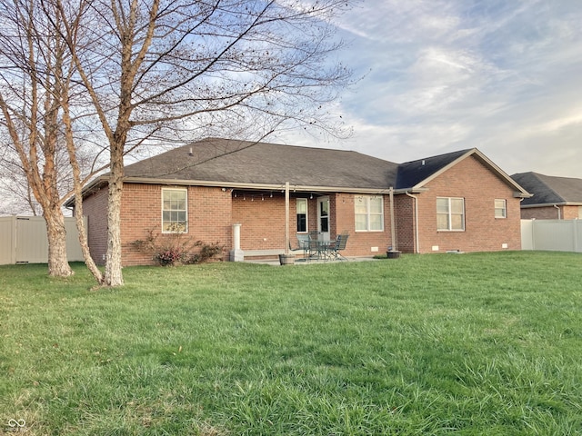 rear view of house featuring a yard and a patio