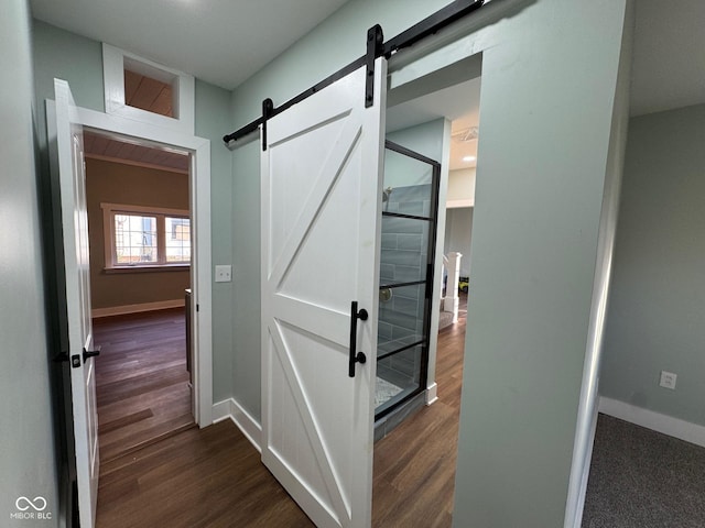 hall with dark hardwood / wood-style floors and a barn door