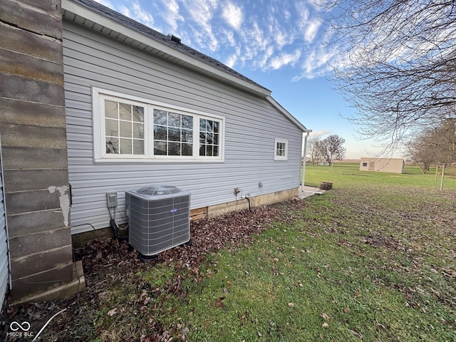 view of home's exterior with a lawn and central AC