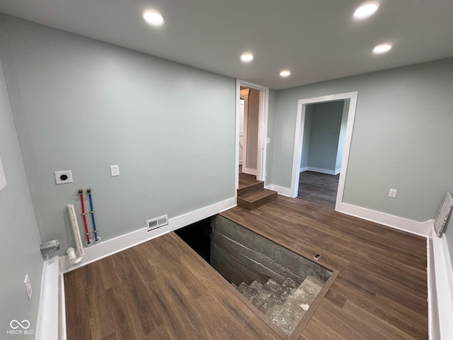 washroom featuring hookup for a gas dryer, dark wood-type flooring, washer hookup, and hookup for an electric dryer