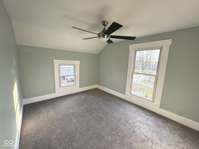 carpeted spare room featuring ceiling fan and vaulted ceiling