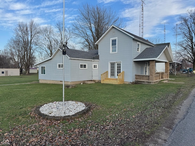 rear view of property featuring a lawn