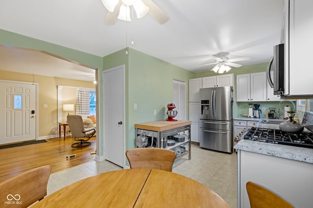 kitchen featuring white cabinets, light hardwood / wood-style floors, a healthy amount of sunlight, and appliances with stainless steel finishes