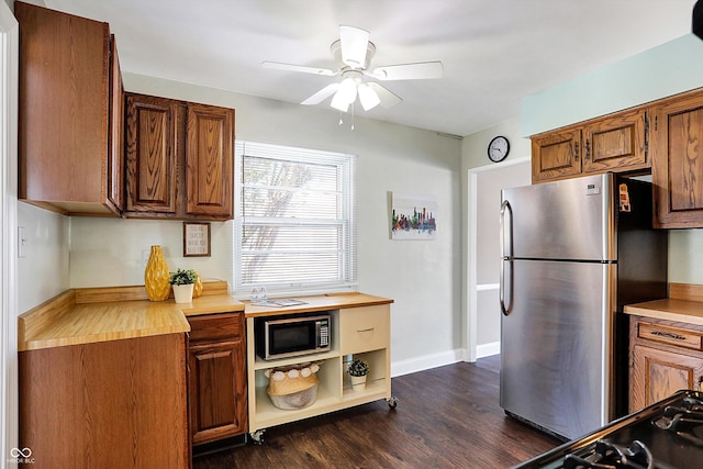 kitchen featuring stainless steel refrigerator, ceiling fan, and dark hardwood / wood-style flooring