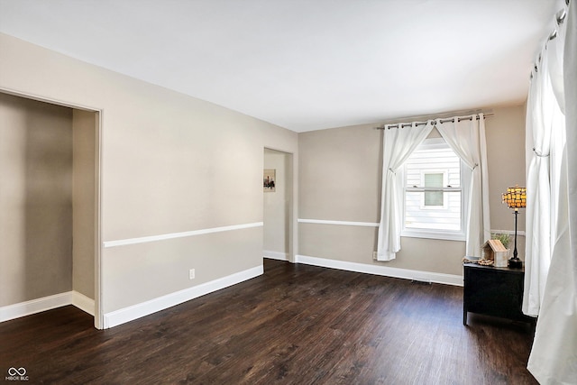 unfurnished room with dark hardwood / wood-style flooring