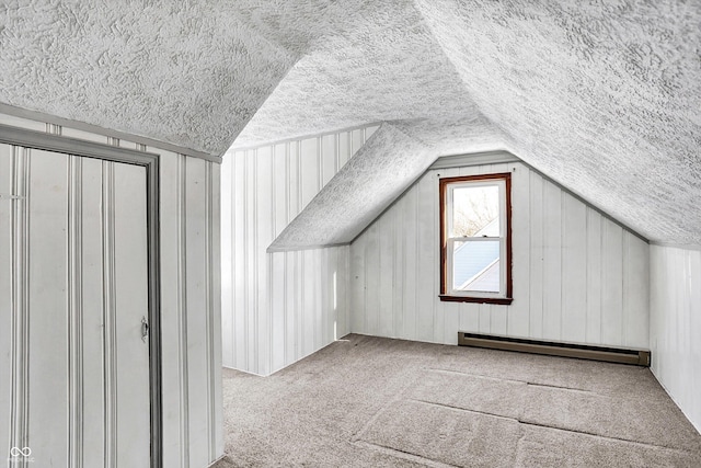 additional living space with a baseboard radiator, lofted ceiling, and carpet flooring