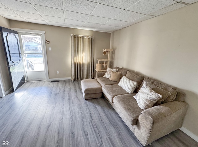 living room with a paneled ceiling and hardwood / wood-style flooring