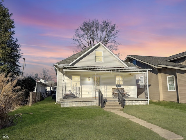 bungalow featuring a porch and a yard