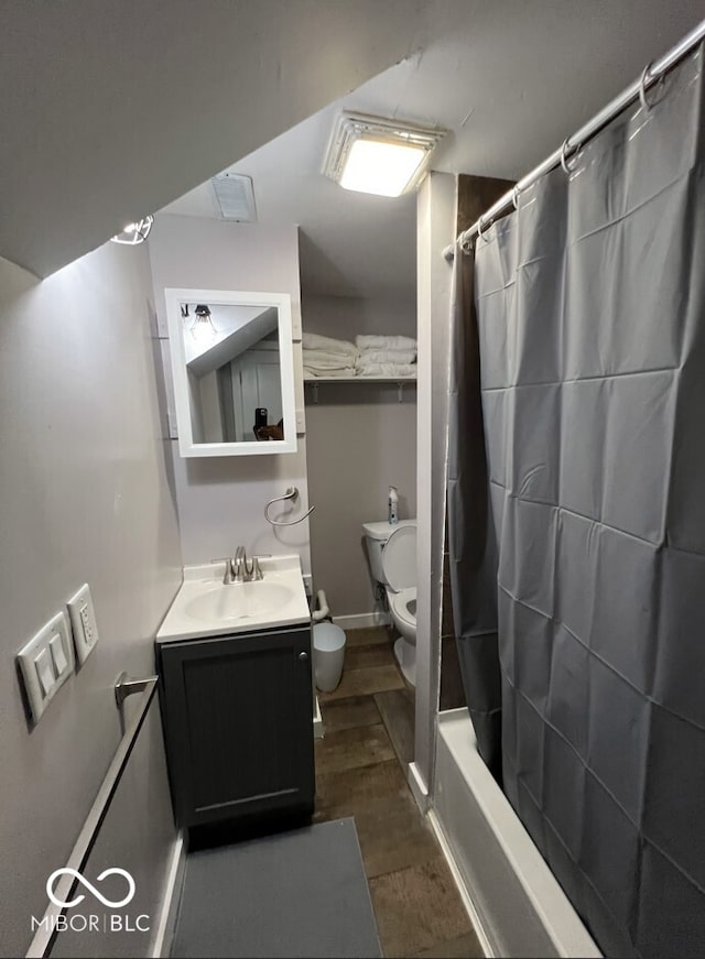 full bathroom featuring shower / bath combo with shower curtain, hardwood / wood-style floors, vanity, and toilet