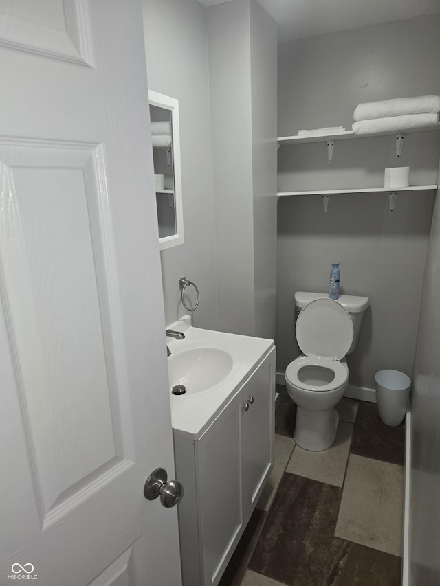 bathroom with tile patterned flooring, vanity, and toilet