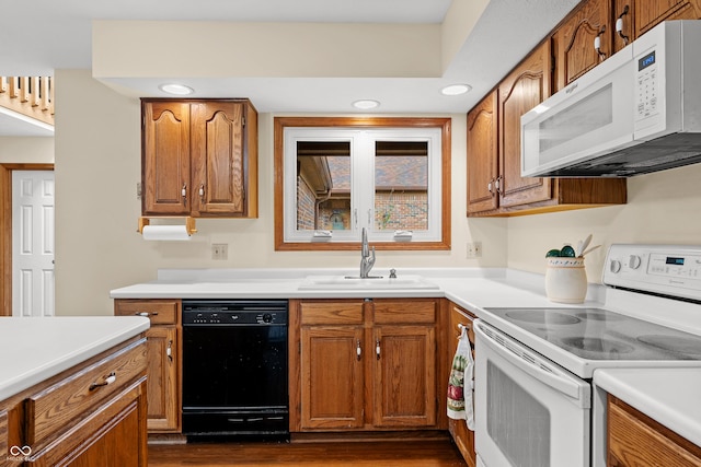 kitchen with dark hardwood / wood-style flooring, white appliances, and sink