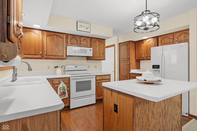 kitchen with a center island, white appliances, sink, and light hardwood / wood-style flooring