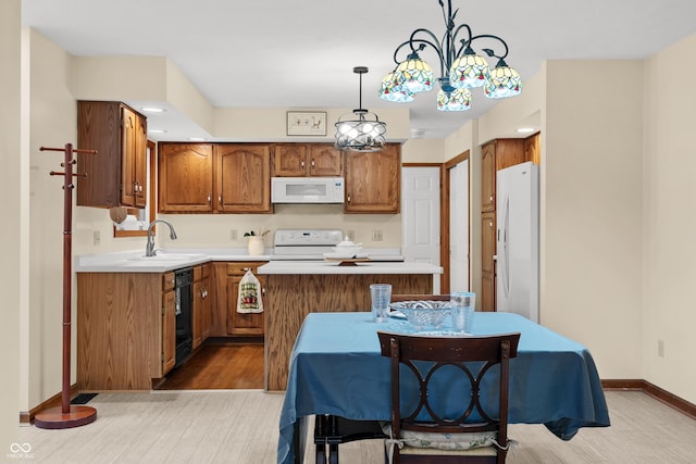 kitchen featuring sink, an inviting chandelier, decorative light fixtures, white appliances, and a kitchen island