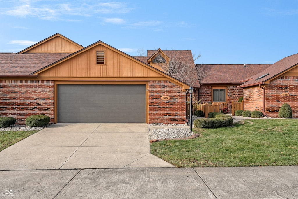 single story home featuring a garage and a front yard